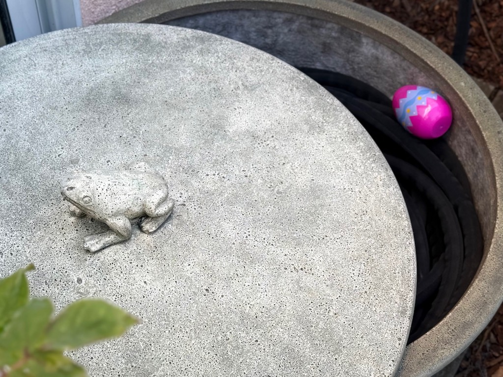 Egg with a clue sits in a hose pot, one of the hiding places.