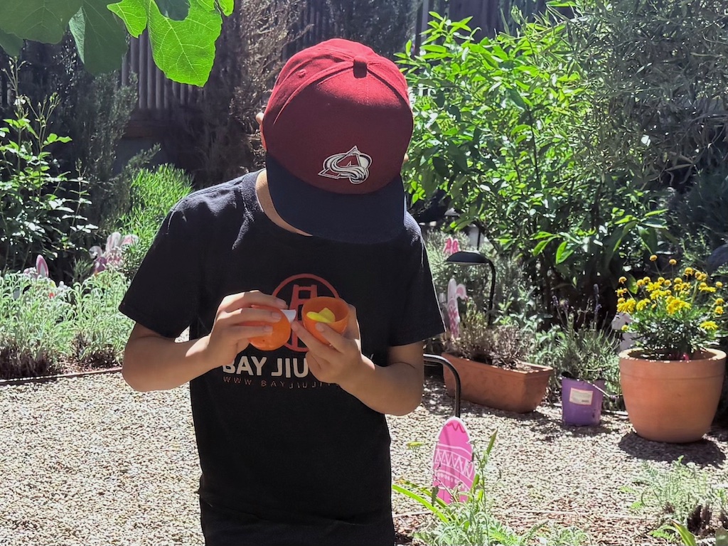 Child opens a plastic egg to find a clue for the Easter egg treasure hunt. There's also a Peep in this egg.