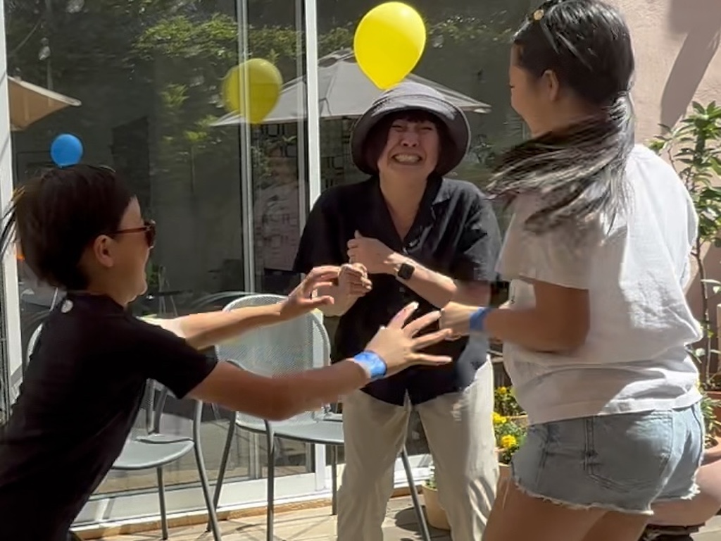 Three generations play games together at our summer party and laughter prevails.