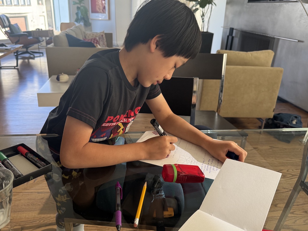 Child lists the ways he appreciates his dad as the first step in making a DIY Father's Day card.