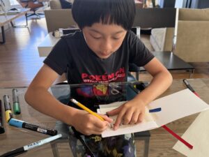 Child traces over tissue paper message flipped over to create mirror writing.