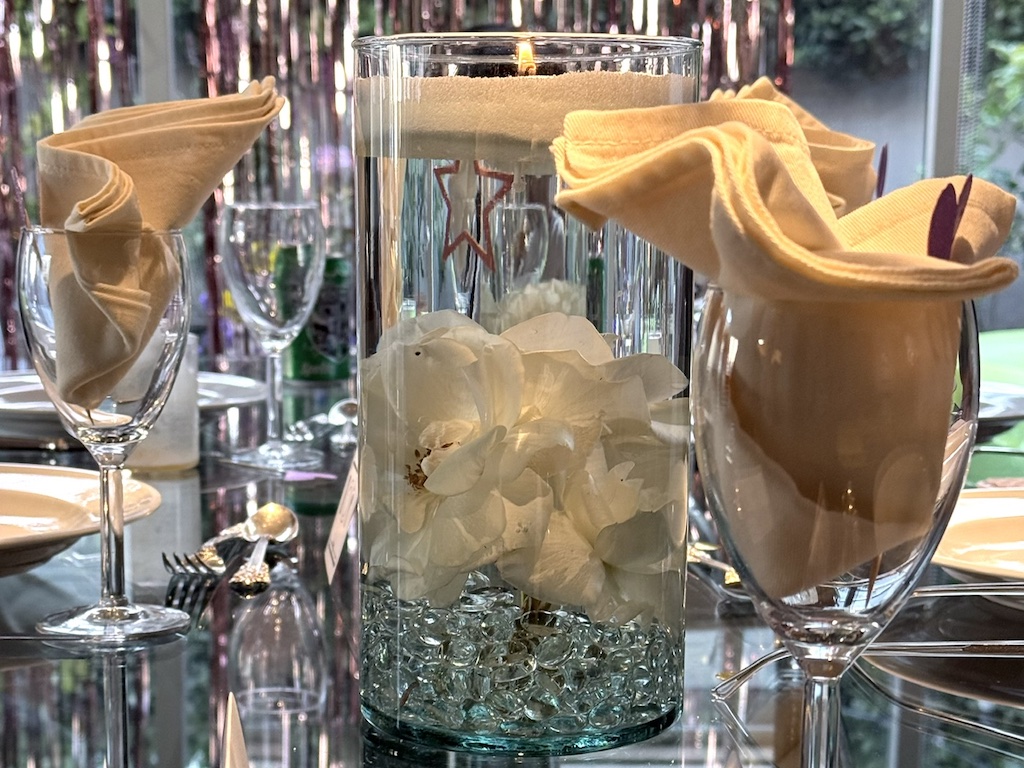 Candle sand table arrangement is lit, casting a glow on the table setting.
