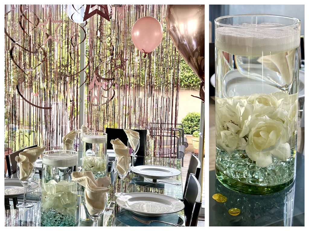 Table is set with candle sand centerpieces: rosers submerged in water and topped with a layer of candle sand that can be lit.