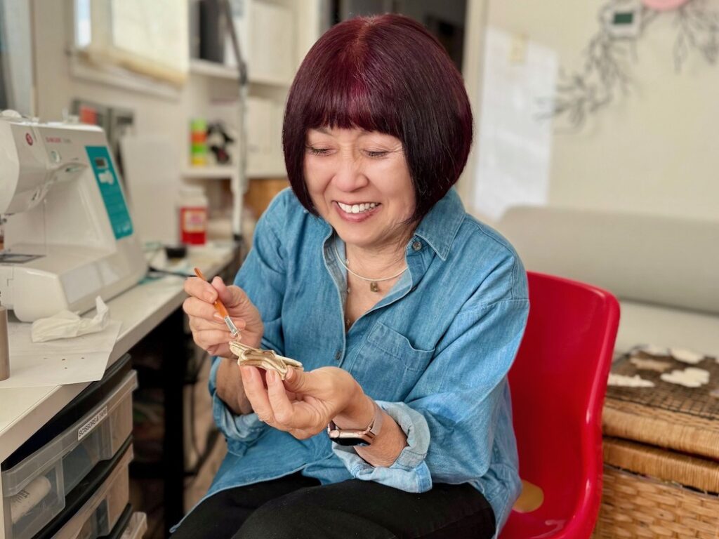Grandma Sandy, the founder of "Call Me Grandma!" makes air dry clay cookie ornaments in her craft room.