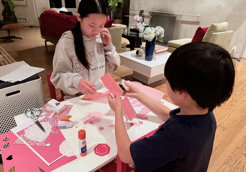 Kids cut out hearts to glue onto clear plasstic placemats.