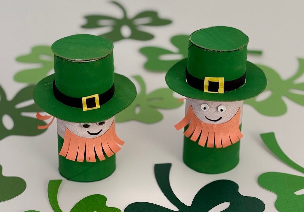 Two leprechauns are made with toilet paper roll, paint, cardboard, and construction paper.