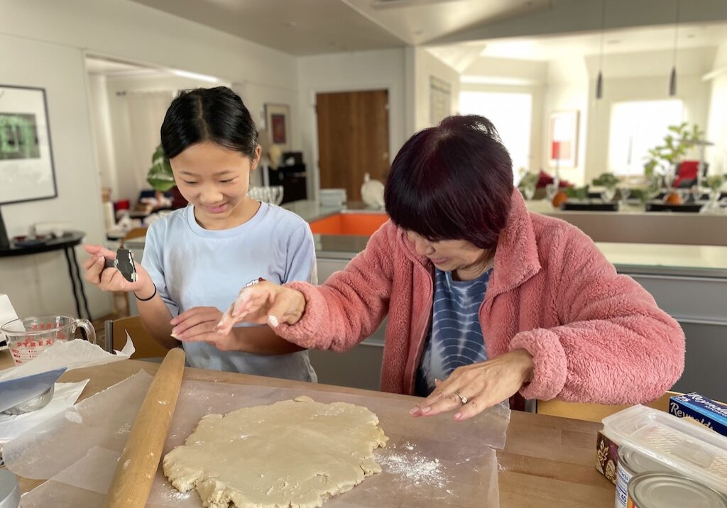 Grandma and grandchild making pie together. Caring for grandkids can help with mental acuity.