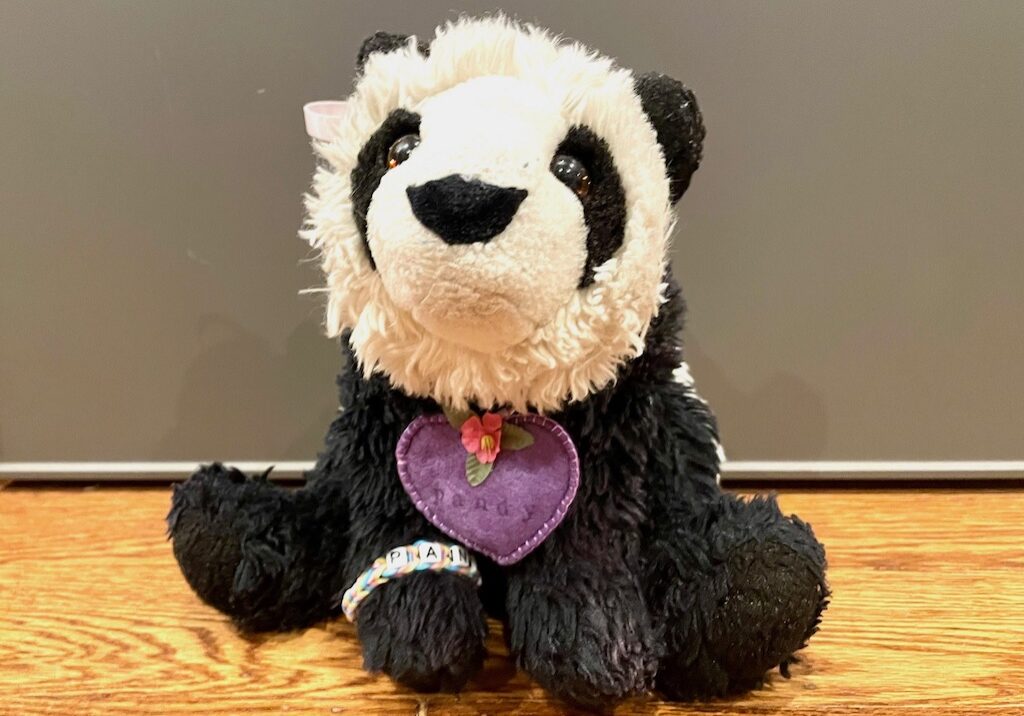 Stuffed panda wears an AirTag heart so she can be tracked, if lost.