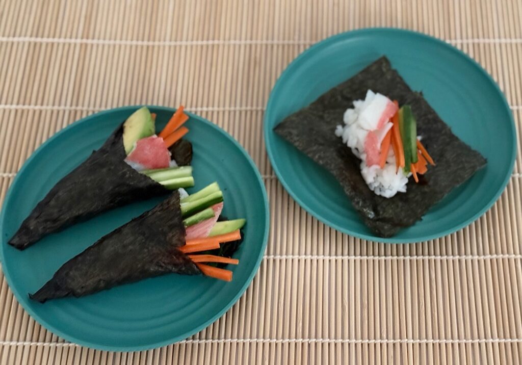Sushi is made by filling nori squares with seasoned rice, vegetable strips, and surimi (imitation crab)